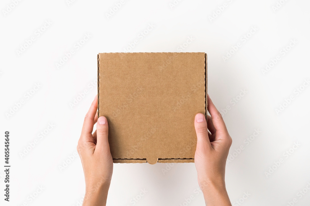female hands holding a small cardboard box on a white background. packaging and delivery concept, top view female hands holding a small cardboard box on a white background. packaging and delivery concept, top view