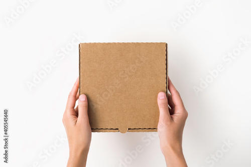 female hands holding a small cardboard box on a white background. packaging and delivery concept, top view © Iryna_B