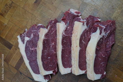 raw steaks on a wood board