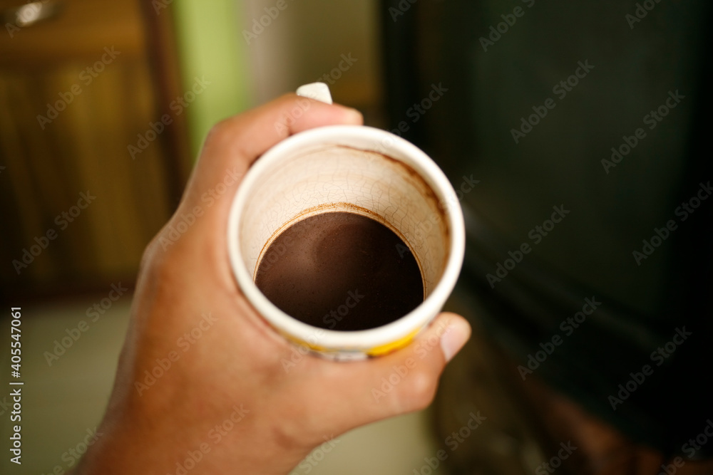 hand holding empty cup of coffee. Dregs in the bottom of the cup hand holding empty cup of coffee. Dregs in the bottom of the cup