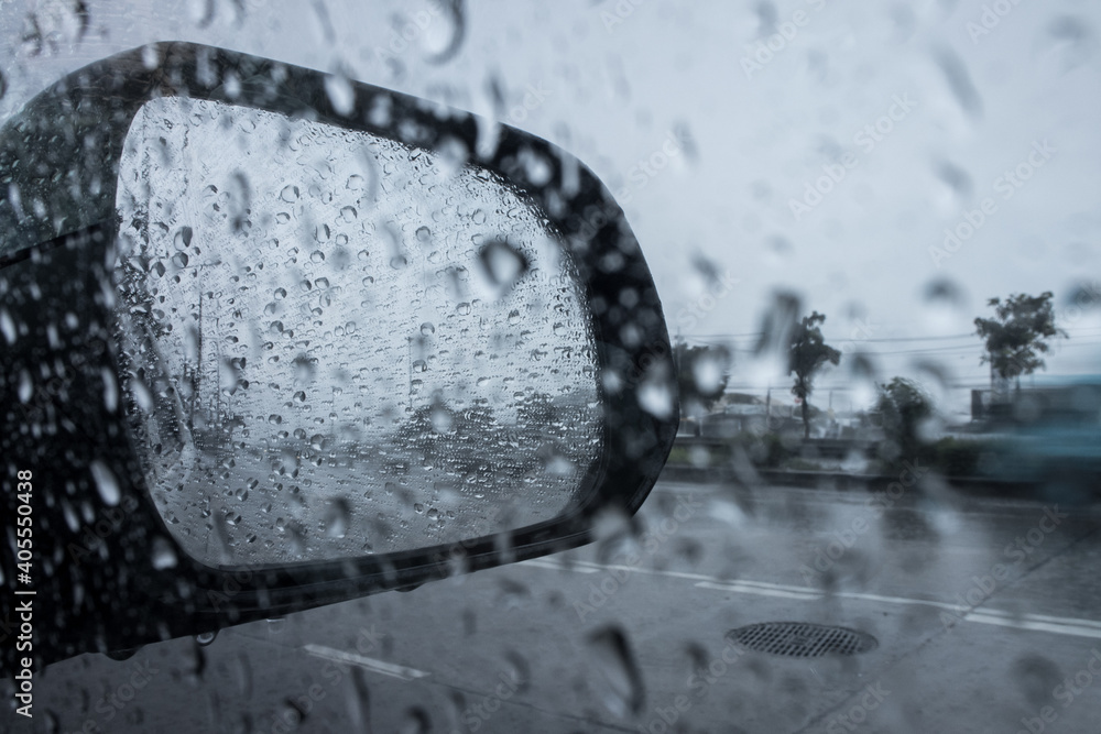 Rain drops on car side mirror.