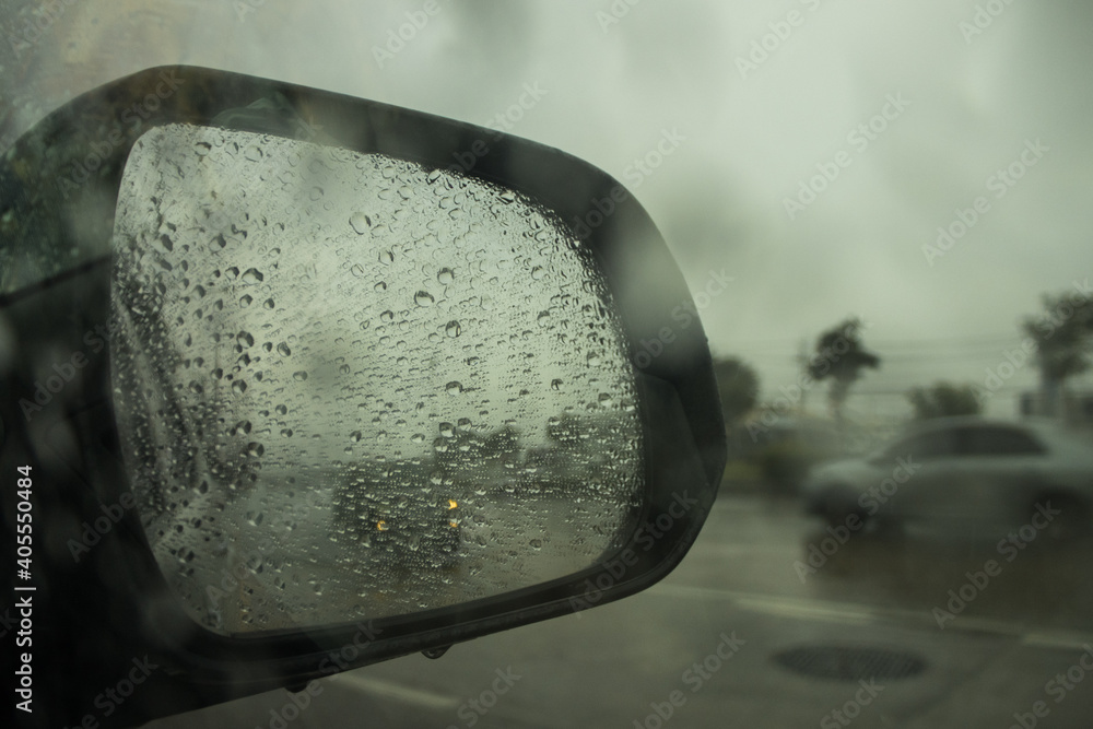 Rain drops on car side mirror.