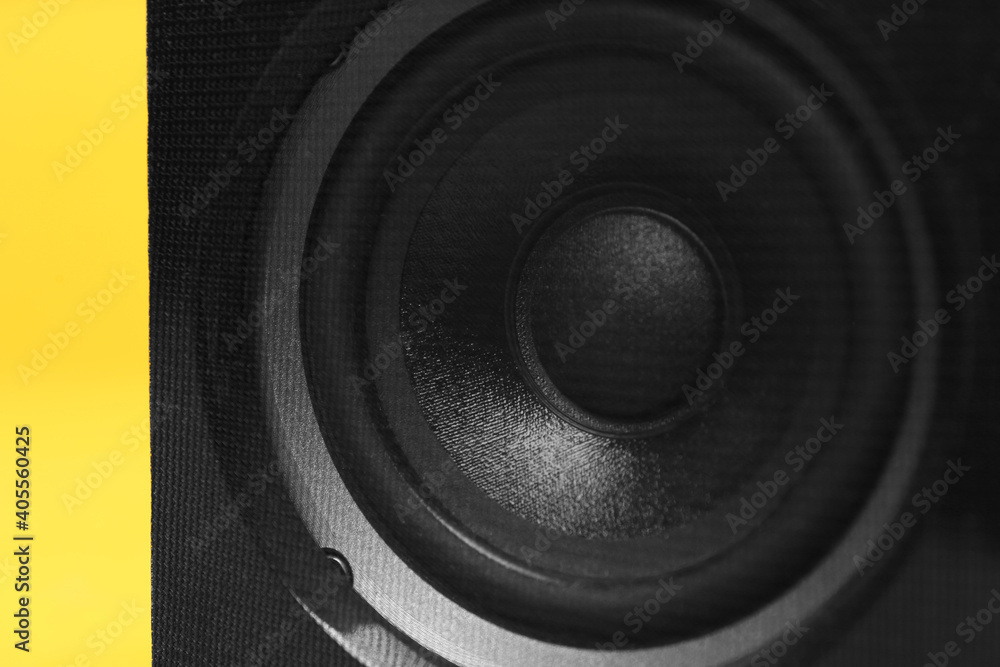 Modern powerful audio speaker on yellow background, closeup Modern powerful audio speaker on yellow background, closeup