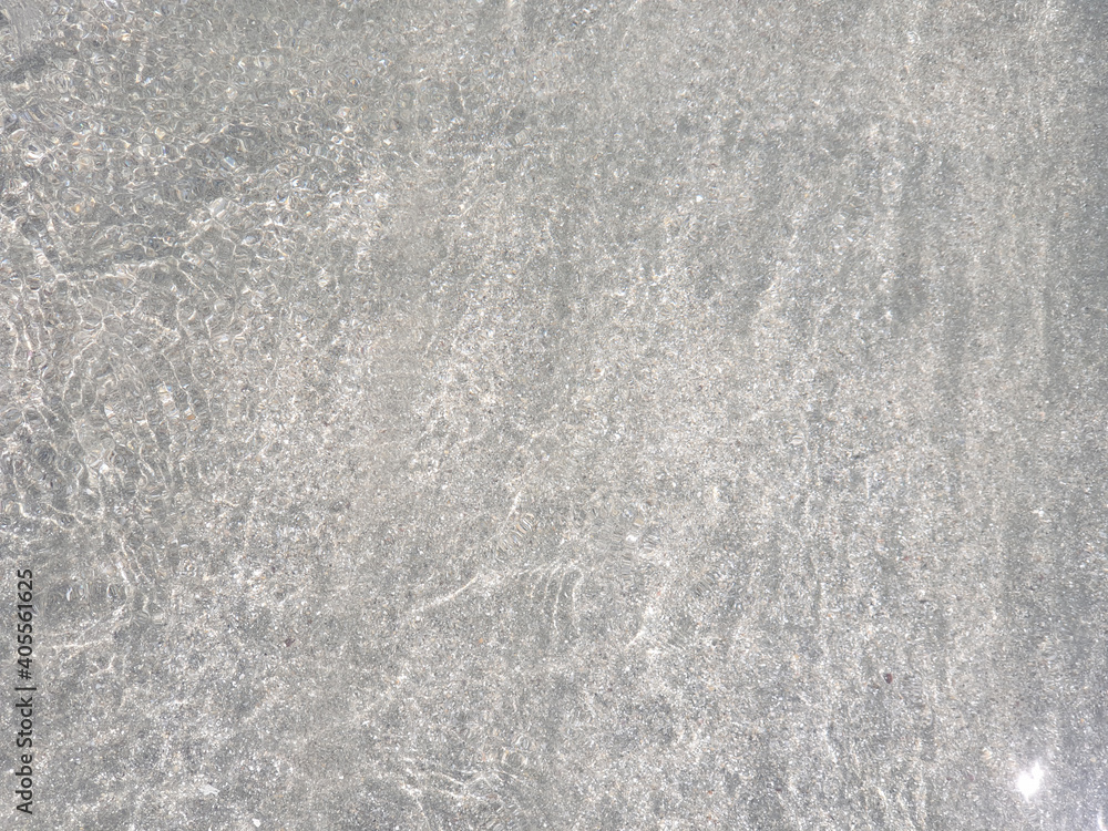 Fototapeta premium The texture of clear water glistening in the sun. Clear sea water for background and texture. Beautiful patterns of nature