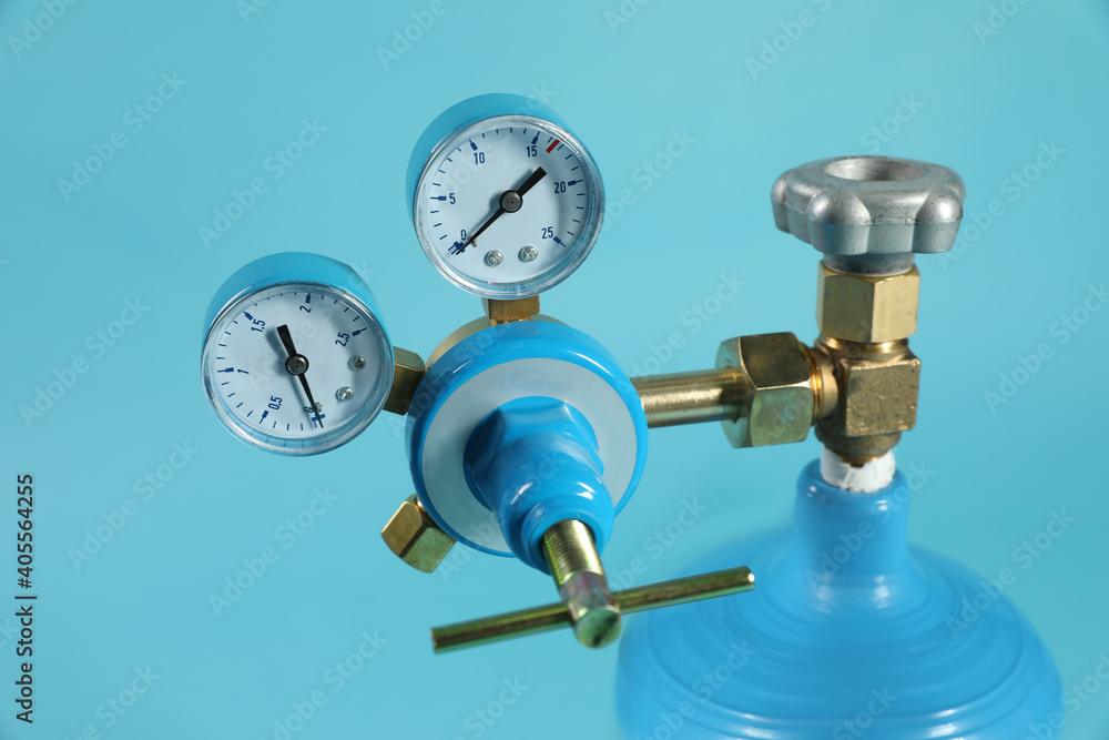 Pressure gauge of medical oxygen tank on light blue background, closeup Pressure gauge of medical oxygen tank on light blue background, closeup