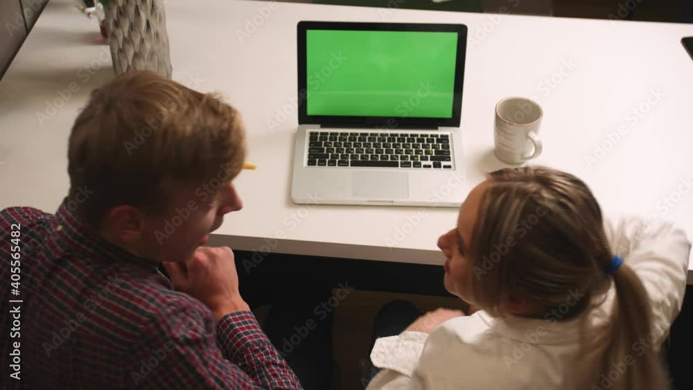 Back view: happy excited couple man and woman using laptop with green screen chromakey at home, happy couple received good news and kissing. Back view: happy excited couple man and woman using laptop with green screen chromakey at home, happy couple received good news and kissing.