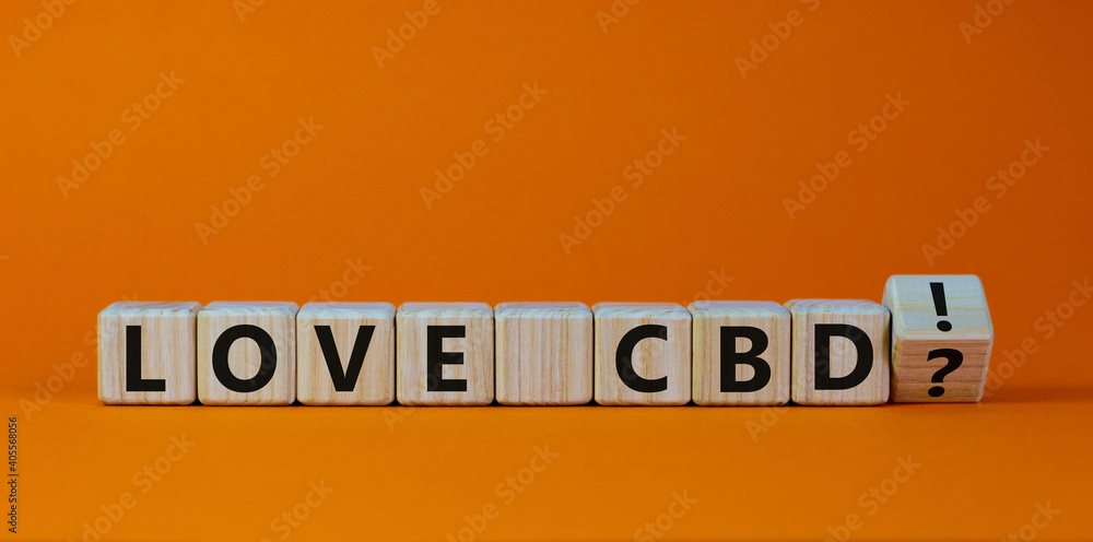 Love CBD, cannabidiol symbol. Wooden cubes with words 'love CBD'. Beautiful orange background, copy space. Medical and love CBD cannabidiol concept. Love CBD, cannabidiol symbol. Wooden cubes with words 'love CBD'. Beautiful orange background, copy space. Medical and love CBD cannabidiol concept.