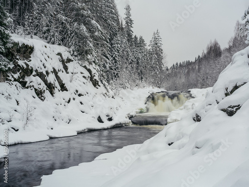 Kivach - waterfall in Karelia, Russia. Winter and snowy forest, january.