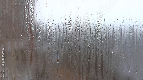 Background of condensation of water droplets on glass, humidity and fog behind glass, bad weather, rain