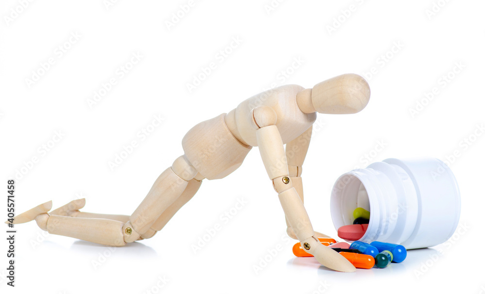 Wooden man with jar pills capsules on white background isolation Wooden man with jar pills capsules on white background isolation