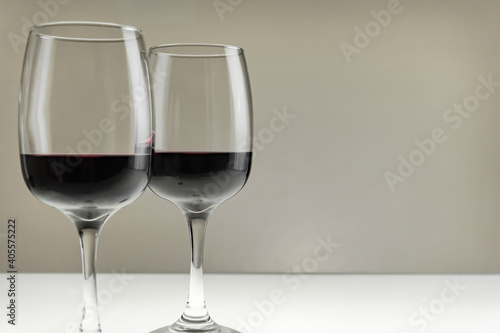 Two large glasses with red wine on a blurred background, close-up.