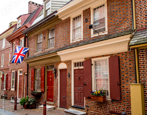 Philadelphia street scene in historical Elfreth's Alley section of the city.  Showing colonial homes with British flag. photo