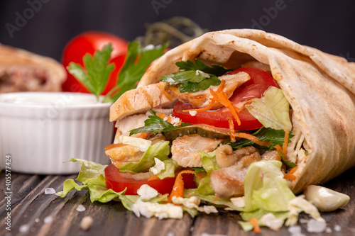 Popular arabic turkish fastfood doner shawarma roll with meat and vegetables and ingredients on wooden background. top view photo