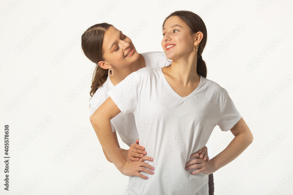 two beautiful young women in white t-shirts on a white background two beautiful young women in white t-shirts on a white background