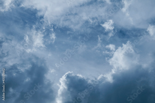 Dramatic dark blue sky with heavy clouds background © Digihelion