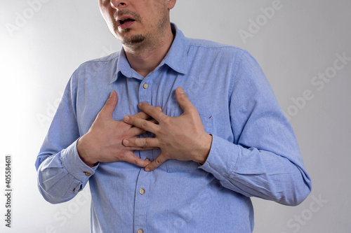 Billede på lærred People, healthcare and problem concept - close up of man suffering from heart ache over gray background