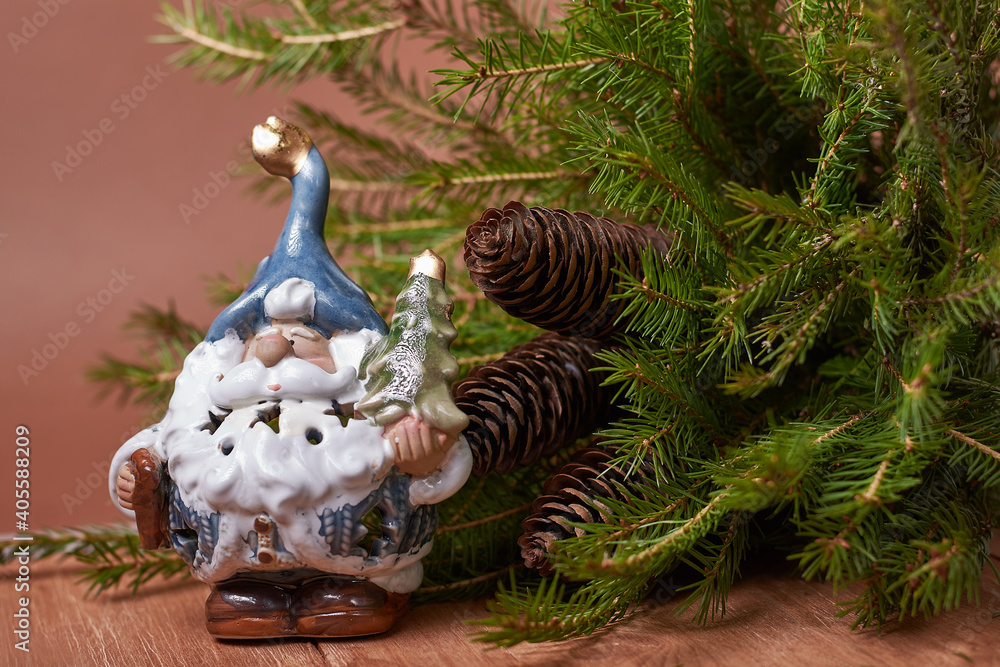 santa claus toy under a fir branch with cones on