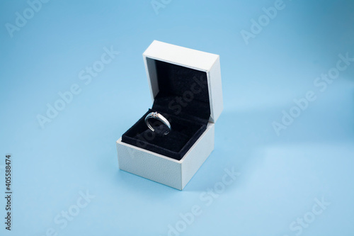 An engagement ring in a box on a blue background. Wedding ring in a box