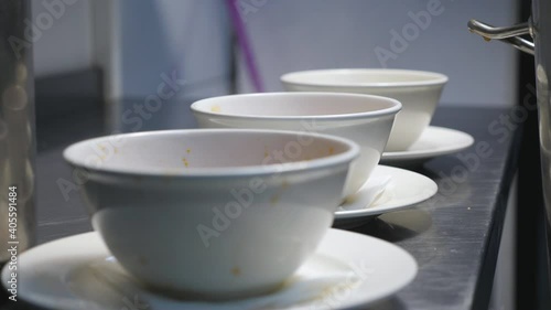 Wallpaper Mural Male cook pouring red beetroot soup from pan in white bowl using a ladle at kitchen. Chef preparing to serve traditional ukrainian and russian borscht at restaurant. Concept of cooking food. Close up Torontodigital.ca