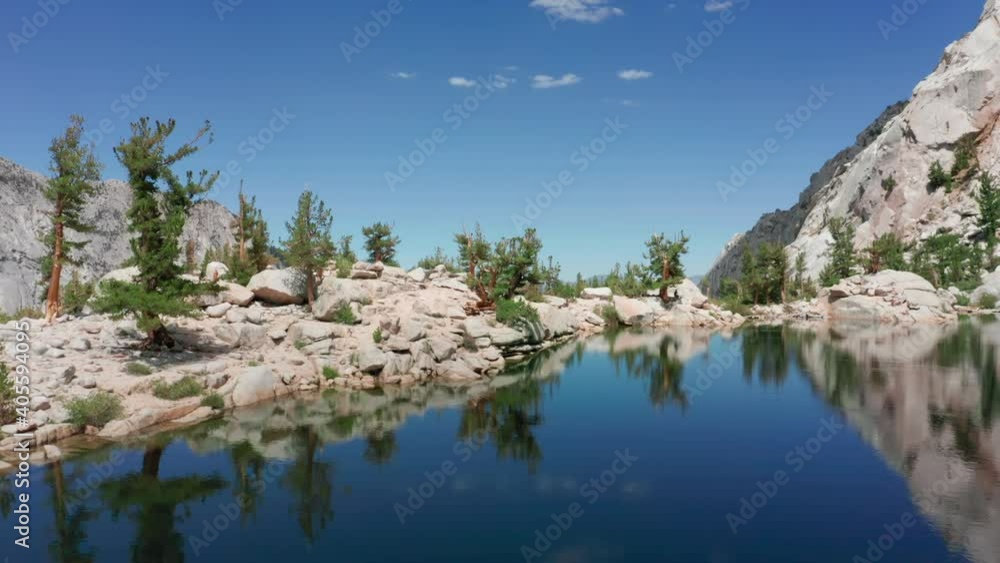Mountain lake with blue water and green trees. Scenic mirror reflection in smooth lake surface. Beautiful summer landscape with mountains, pine trees and lake. Nature background with copy space aerial Mountain lake with blue water and green trees. Scenic mirror reflection in smooth lake surface. Beautiful summer landscape with mountains, pine trees and lake. Nature background with copy space aerial