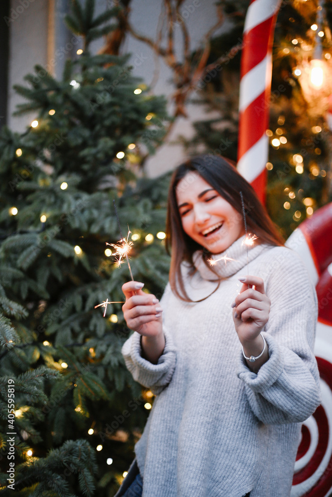 young woman smiling and celebrating new year and Christmas with sparklers. blurred young woman smiling and celebrating new year and Christmas with sparklers. blurred