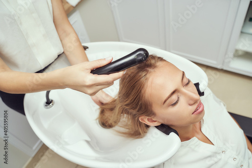 Long hair woman. Hairdresser treatment. Repair procedure. Wash at salon. Bride hairstyle. Master hand with watering can. Adult female person. Wet lady preparation. Blonde dry. Copyspace