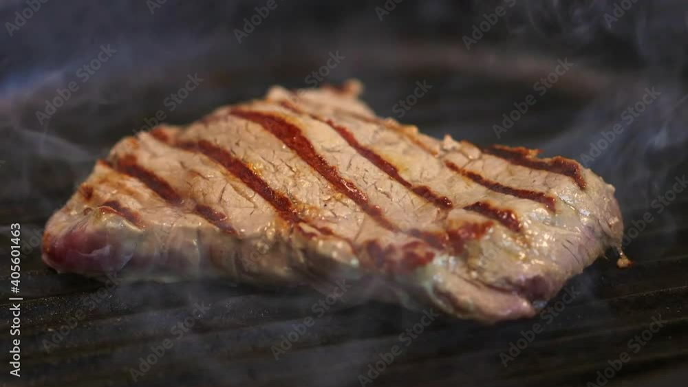 beef steak is fried on a hot smoky grill pan beef steak is fried on a hot smoky grill pan