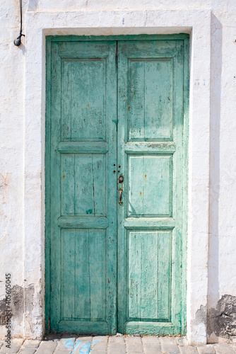 Green wooden door of a whitewashed house, typical of the town of Teguise, in Lanzarote © NoemiEscribano