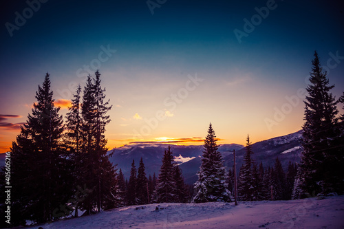 Beautiful dawn in the winter snow-covered mountains and amazingly beautiful clouds