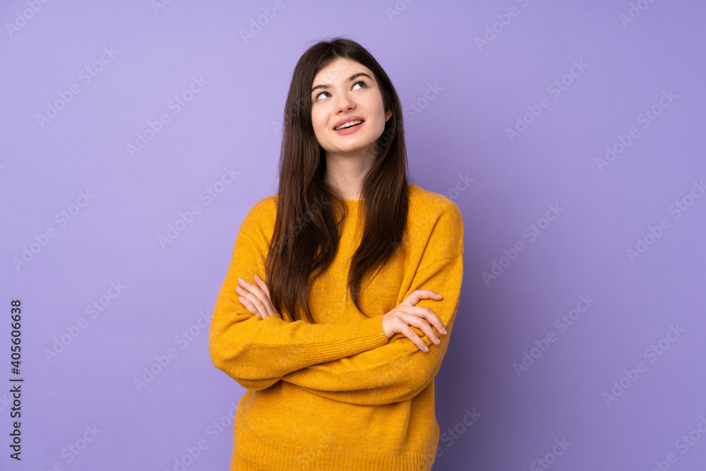 Young Ukrainian teenager girl over isolated purple background looking up while smiling Young Ukrainian teenager girl over isolated purple background looking up while smiling