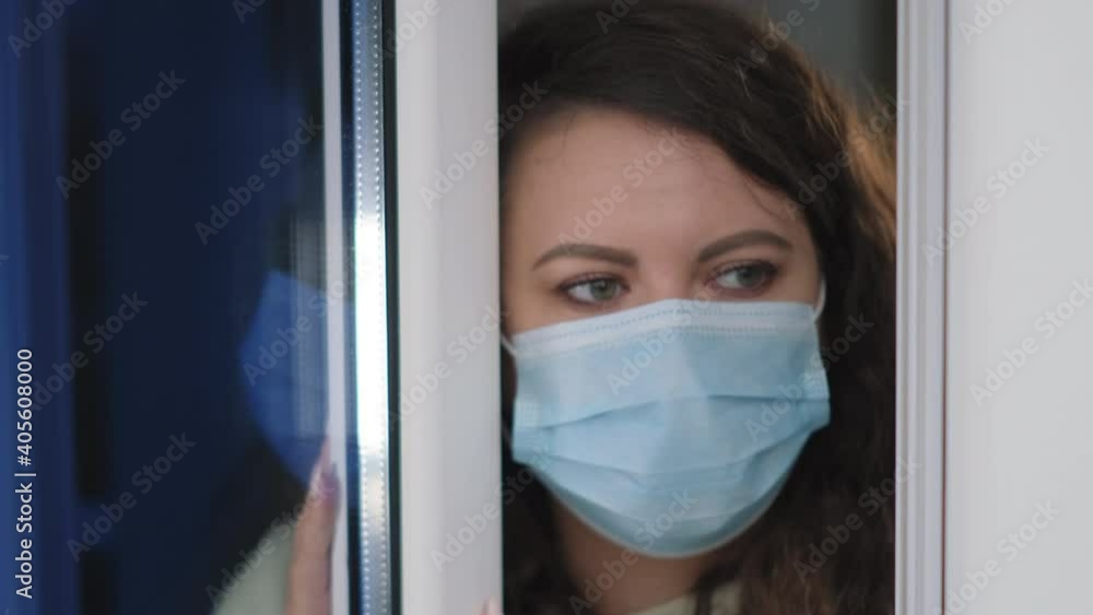 Woman in quarantine looking out the window Woman in quarantine looking out the window