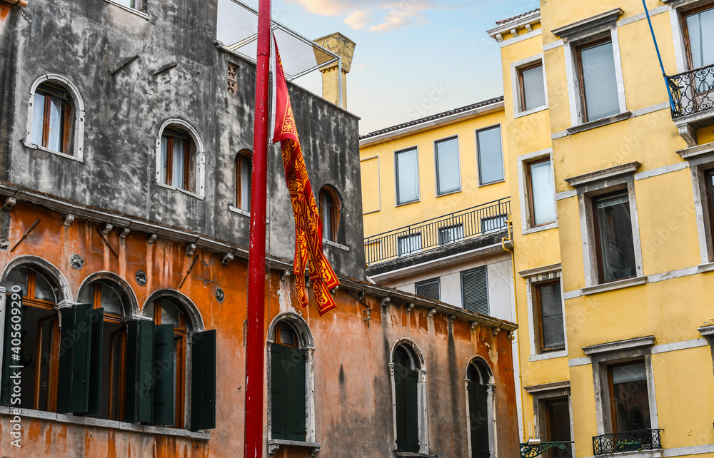 The red and yellow flag of Venice flies in a piazza in Venice, Italy.