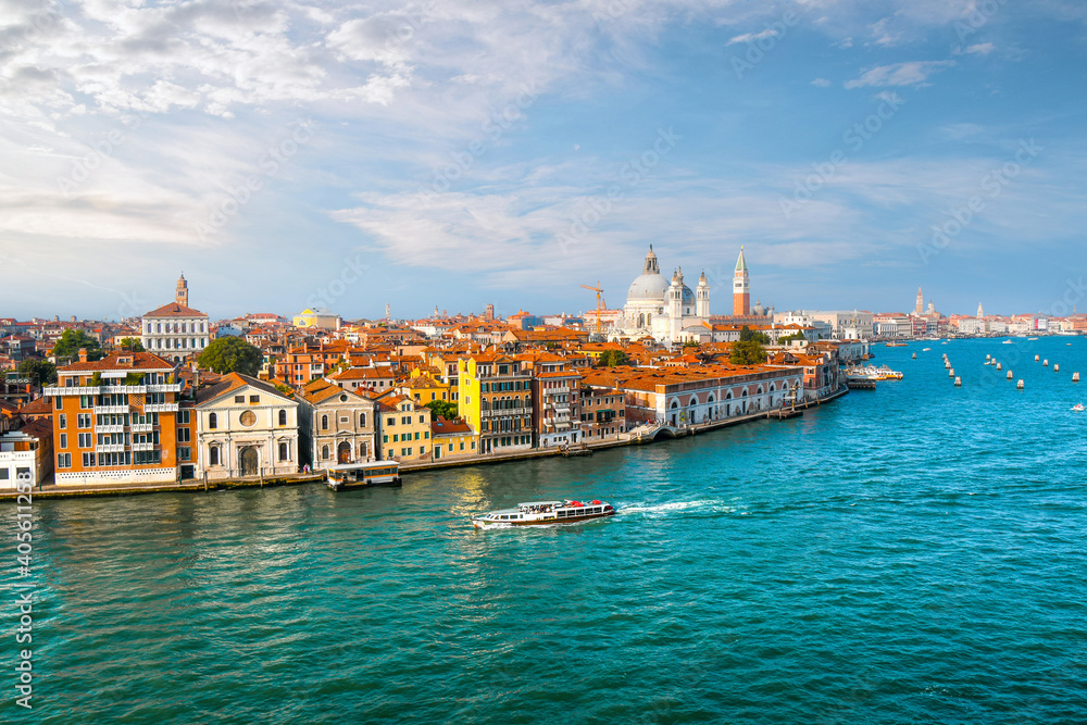 A Venice, Italy water taxi cruises the grand canal with the dome of Santa Maria Della Salute Cathedral, the Campanile and St. Mark's square in view