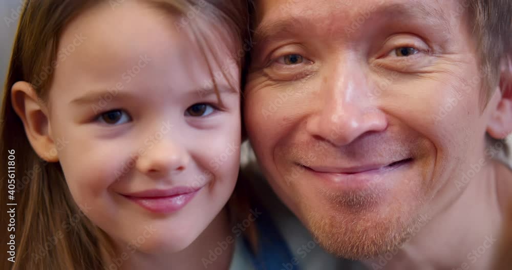 Close up portrait of happy father and little daughter smiling at camera Close up portrait of happy father and little daughter smiling at camera