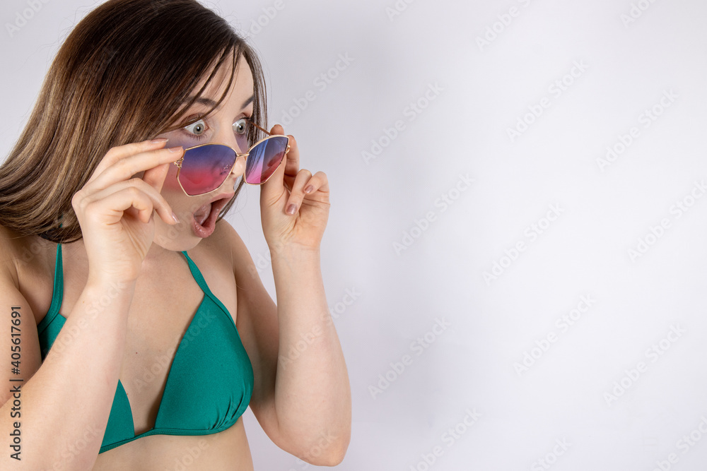 Head shot photo of an attractive young slim sexy woman in a green bikini and sun glassless looking shocked at a summer deal summer time enjoyment concept Head shot photo of an attractive young slim sexy woman in a green bikini and sun glassless looking shocked at a summer deal summer time enjoyment concept