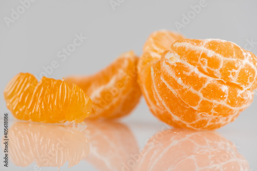 juicy sweet tangerine, part of which was peeled on a light background, side view. High key. There is a place for an inscription. Selective focus 