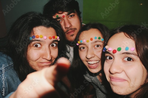 group of friends of four having fun and smiling in colorful setting