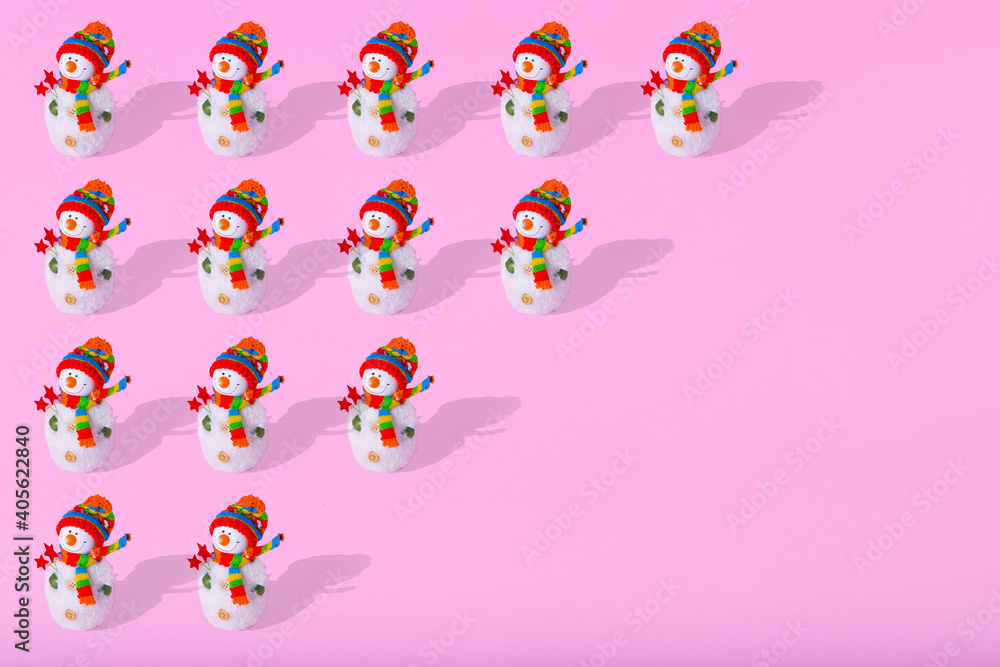 Minimal winter pattern made of snowman on light pink background.