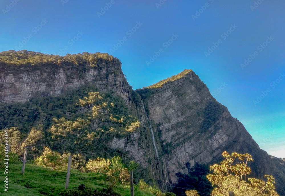 Waterfall in a mountain with a  blue sky and trees