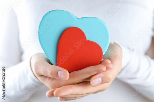 Female hands holding heart shape blue gift box with red heart  gift for him  Valetines day gift