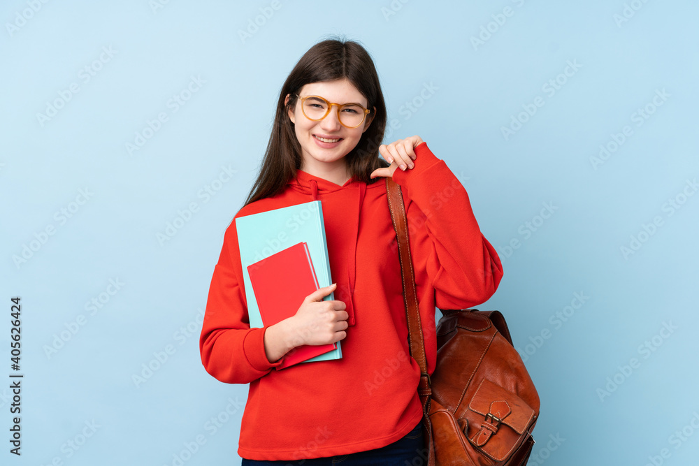 Obraz premium Young Ukrainian teenager student girl holding a salad over isolated blue background proud and self-satisfied