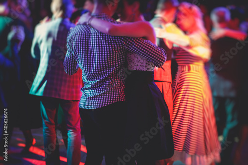 Couples dancing traditional latin argentinian dance milonga in the ballroom, tango salsa bachata kizomba lesson in the red lights, dance festival
