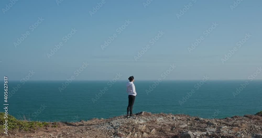 Woman stand on the top of mountain with blue sky