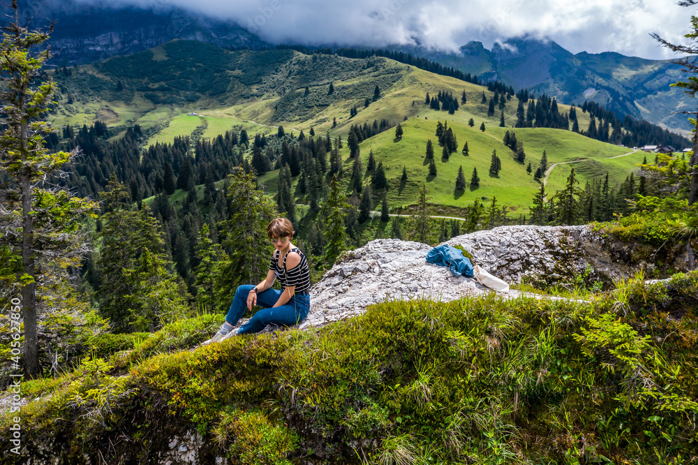 Young girl in the mountains. Alpine expanses. Freedom and space all around.