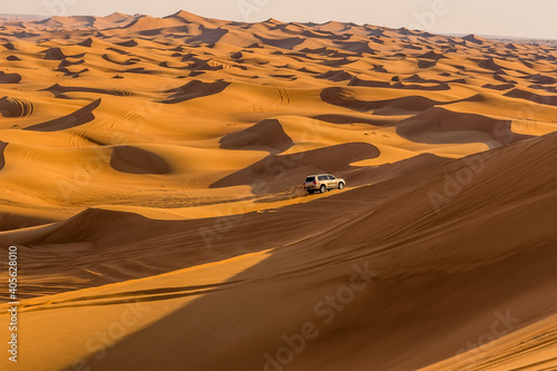 A lone vehicle on a desert safari in the red desert at Hatta near Dubai, UAE in springtime photo