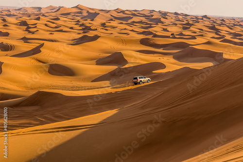 Photography A lone vehicle on a desert safari in the red desert at Hatta near Dubai, UAE in