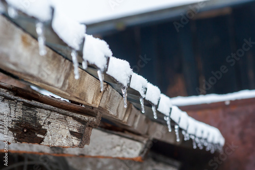 Winter icicles hanging from eaves of roof backgrouind