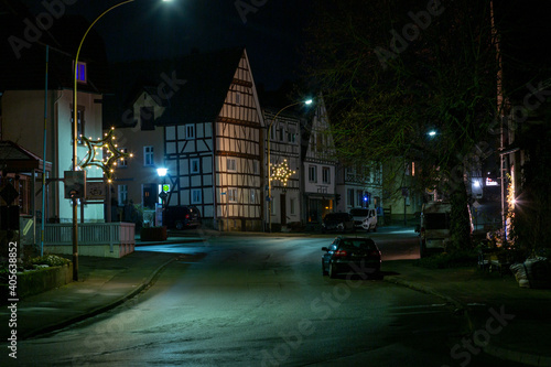 Night scene of an old German town with studwork houses and cobbled street in wet weather © Aquarius