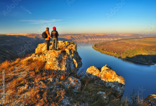 Fototapeta Naklejka Na Ścianę i Meble -  couple of tourists on the rock. a man and a woman look at the picturesque river canyon
