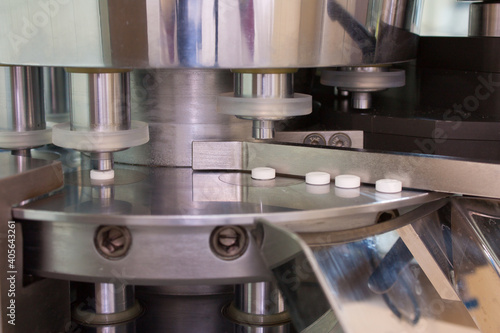 Drug tablet and pill rotary press machine in in the lab ore medicine manufacturing factory health and hospital background concept. Рharmaceutical laboratory.